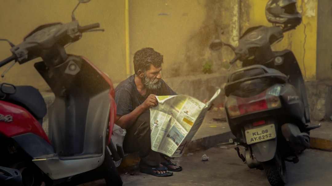 A man sitting on a motorcycle reading a map