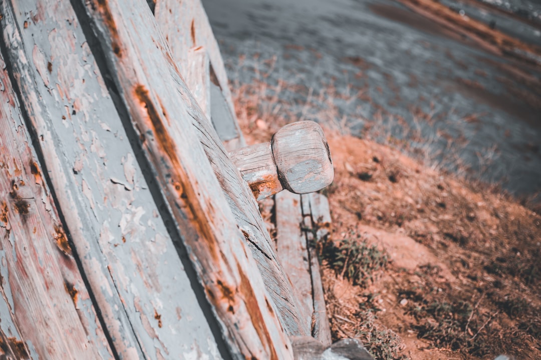 an old wooden bench sitting on the side of a road