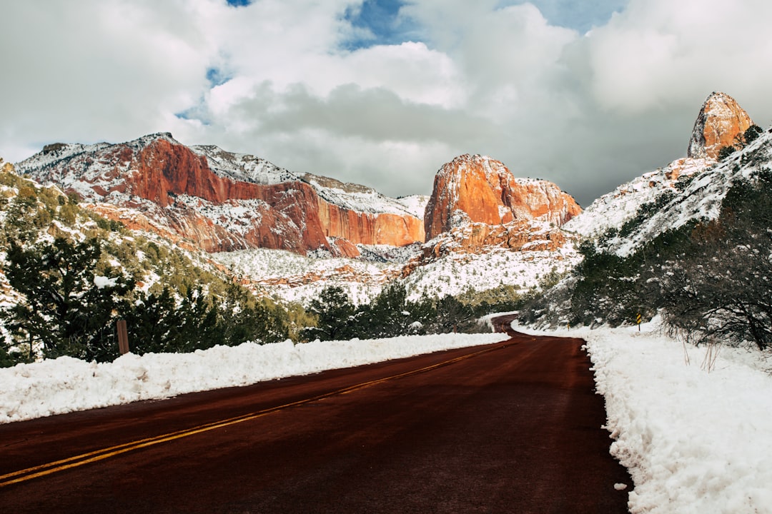 A snow covered road with mountains in the background